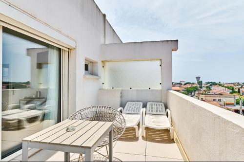 a patio with a table and chairs on a balcony at Hôtel Les Sables - Urban Style - by Logis Hotels in Canet-en-Roussillon