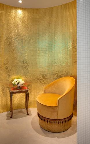 a chair and a table with a vase of flowers at Hôtel Kleber Paris & Spa in Paris