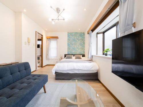 a bedroom with a bed and a couch and a tv at Omotesando Sta 8min walk,Shibuya,Harajuku 3min,10GB net, PocketWiFi, Switch in Tokyo