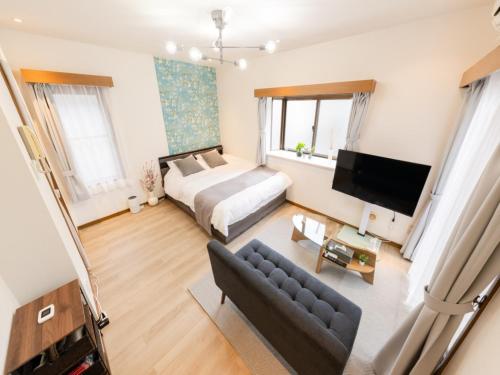 a bedroom with a bed and a couch at Harajuku 3min, Omotesando 8min walk, Shibuya Area, Switch,Free Wi-Fi, PocketWi-Fi in Tokyo