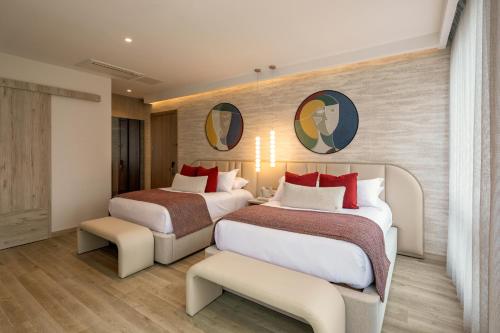 two beds in a hotel room with red pillows at Le Parc Hotel, Beyond Stars in Quito