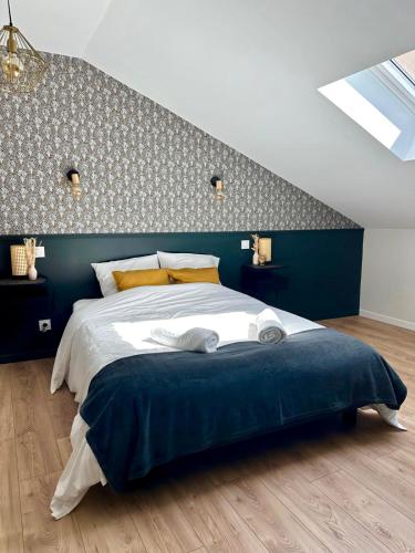a bedroom with a large bed with a blue wall at La longère Cosy & Centrale in Bétheny