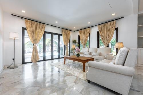 a living room with a couch and a table at Luxury Bungalow TTDI, 16-22pax, Swimming Pool, One Utama in Kuala Lumpur