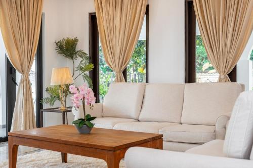 a living room with a white couch and a table at Luxury Bungalow TTDI, 16-22pax, Swimming Pool, One Utama in Kuala Lumpur
