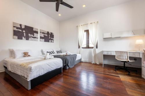 a bedroom with two beds and a desk at Luxury Bungalow TTDI, 16-22pax, Swimming Pool, One Utama in Kuala Lumpur