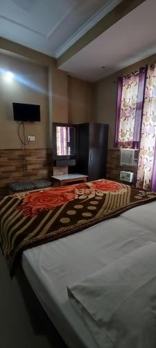 a large bed in a room with a television at Hotel Ishaan International Near Yatra Parchi Counter in Katra