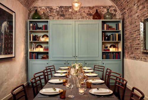 a dining room with a long table and chairs at The Hoxton, Paris in Paris