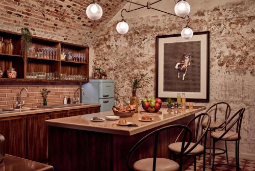 a kitchen with a bar with chairs and a table at The Hoxton, Paris in Paris