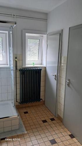 a bathroom with a black radiator and a window at Harzklub Wanderheim in Wildemann