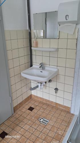 a bathroom with a sink and a tiled floor at Harzklub Wanderheim in Wildemann