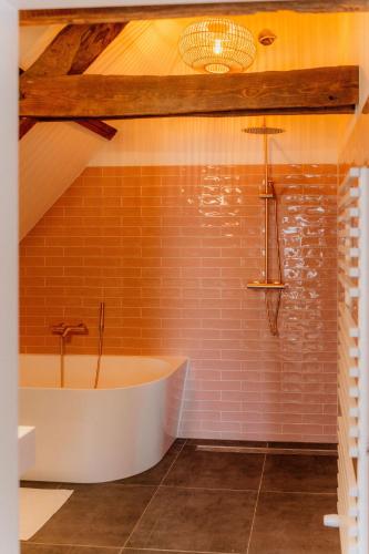 a bathroom with a white tub and red tiles at Landgoed Frymerson in Sint Odiliënberg