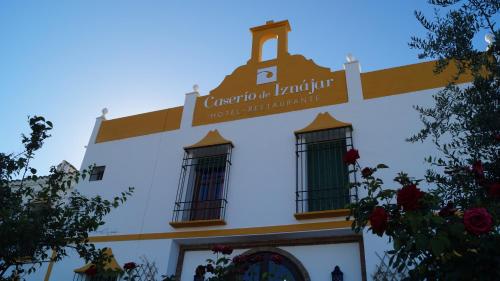 a building with a sign on the side of it at Caserio de Iznájar in Iznájar