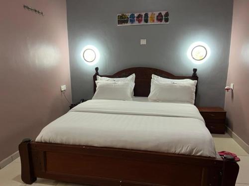 a bedroom with a large bed with white sheets and pillows at REBERO RESORT Ltd in Kigali