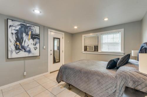 een slaapkamer met een bed en een schilderij aan de muur bij 2 Mi to Dtwn Pensacola Dog-Friendly Apartment in Pensacola