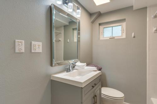een witte badkamer met een wastafel en een spiegel bij 2 Mi to Dtwn Pensacola Dog-Friendly Apartment in Pensacola