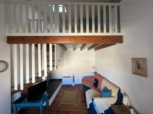 a living room with a couch and a staircase at Le Cocon de la Grande Rue in Tournon-sur-Rhône