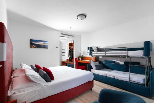 a bedroom with two bunk beds and a couch at Hotel O Sole Mio in SantʼAgata sui Due Golfi