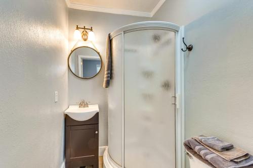 a bathroom with a shower and a sink and a mirror at 3 Blocks to Pensacola Bay Charming Apartment! in Pensacola