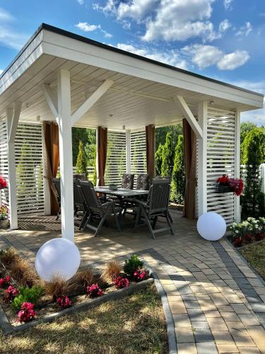 a pavilion with a table and chairs on a patio at Sosenkowe Apartamenty in Kuźnica Głogowska