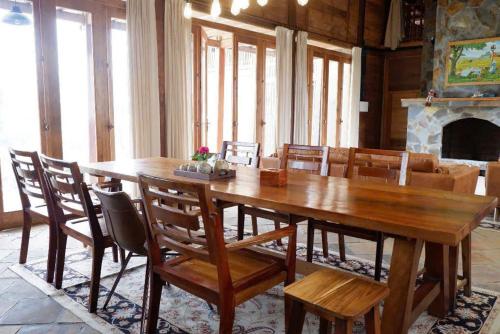 a wooden table and chairs in a room with a fireplace at M-Stay Thạch Thất Hà Nội in Ðào Lãng