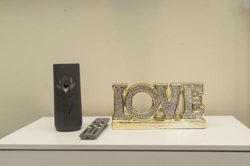 a white shelf with the word love next to a remote control at Paradise View in Discovery Bay