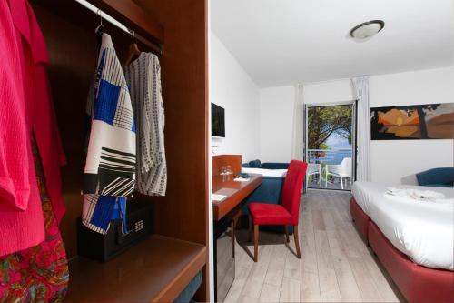 a hotel room with a bed and a bedroom with a desk at Hotel O Sole Mio in SantʼAgata sui Due Golfi