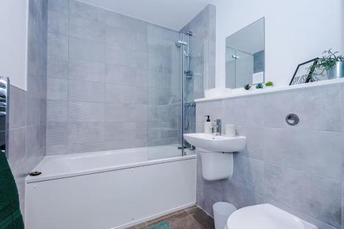 a bathroom with a toilet and a shower and a sink at Quayside Living in Manchester