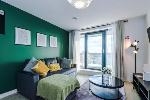 a living room with a couch and a green wall at Quayside Living in Manchester