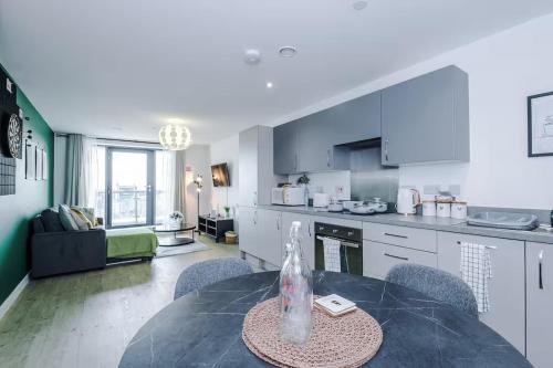 a kitchen and living room with a table and chairs at Quayside Living in Manchester