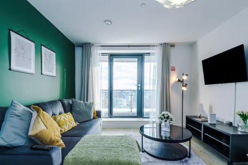 a living room with a couch and a tv at Quayside Living in Manchester