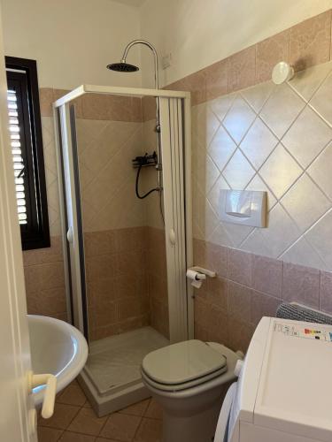 a bathroom with a shower and a toilet and a sink at appartamento Palau in Barrabisa