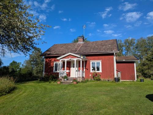 an old red house with a grass yard at Beautiful Idhult 2 in Aneby