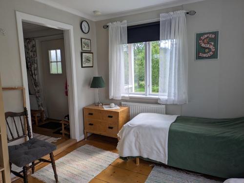 a bedroom with a bed and a chair and a window at Beautiful Idhult 2 in Aneby