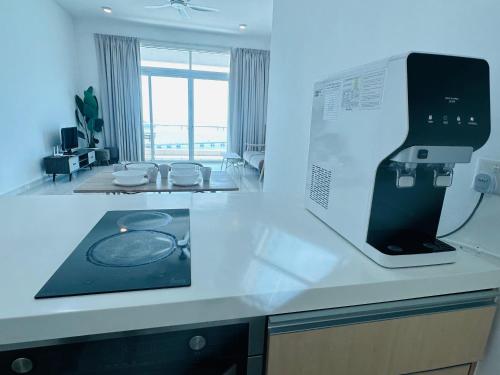 a kitchen with a counter top with a microwave at Southbay Seaview Condo A31 #10minQueensbay in Bayan Lepas