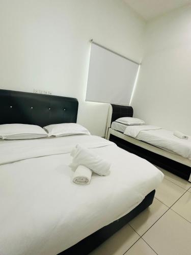a room with two beds with towels on them at Southbay Seaview Condo A31 #10minQueensbay in Bayan Lepas