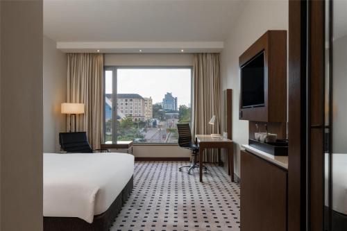 内罗毕Radisson Blu Hotel, Nairobi Upper Hill的一间带床和大窗户的酒店房间