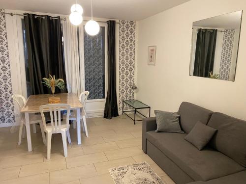 a living room with a couch and a table at Appartement 2 chambres 5 pièces paisible in Villefranche-sur-Saône