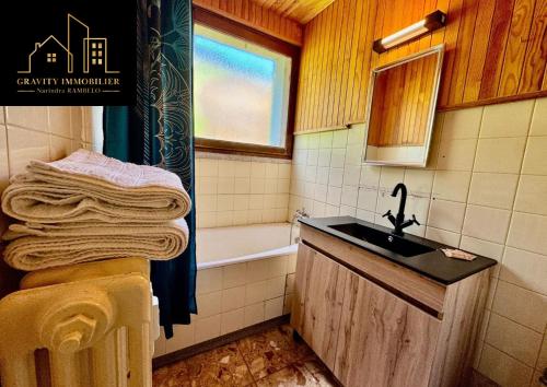 un bagno con lavandino e vasca da bagno di L'essentiel a Megève
