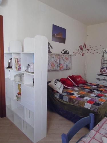 a bedroom with a bed and white shelves at Un letto nel cortile in Bereguardo