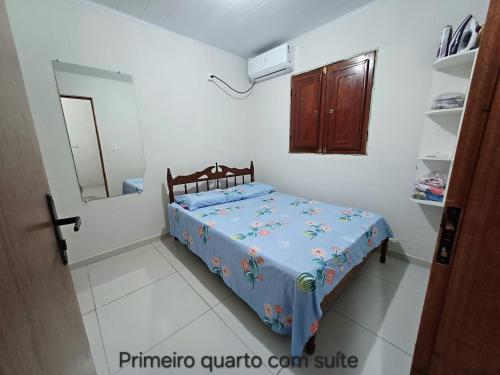 a bedroom with a bed with a blue comforter at Casa no centro de Japaratinga in Japaratinga