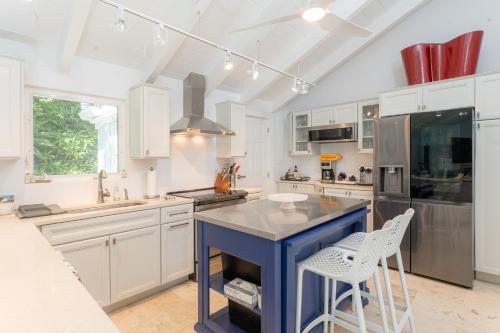 a kitchen with a blue island and white cabinets at Seas The Bay in Enighed