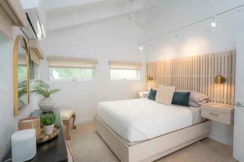 a white bedroom with a bed and a window at Seas The Bay in Enighed