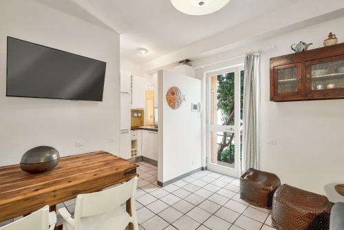 a dining room with a table and a television on the wall at Terrazza Nico Seaview Terrace in Portovenere