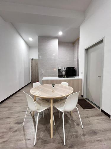 a dining room with a table and white chairs at The Executive 27 by MySky Putrajaya in Putrajaya