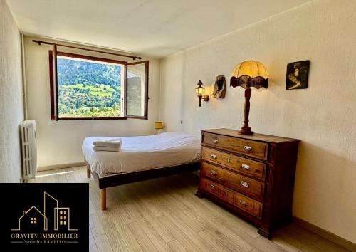 una camera da letto con un letto e una cassettiera con una finestra di L'essentiel a Megève