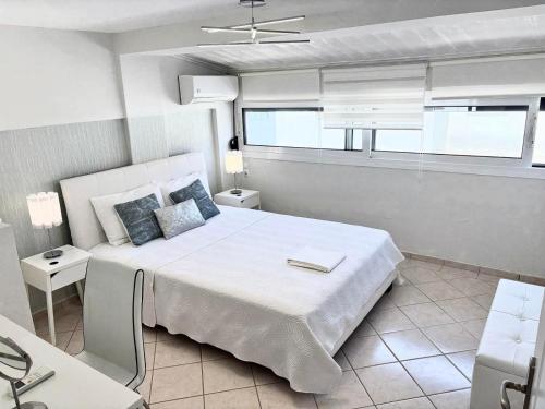 スキアトスタウンにあるAmazing Maisonettes in Skiathosの大きなベッドと窓のある白い寝室