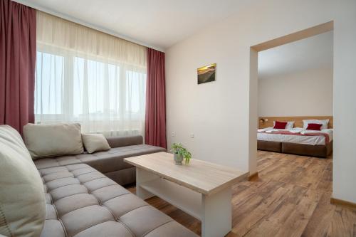 a living room with a couch and a table at Хотел Орфей in Kŭrdzhali