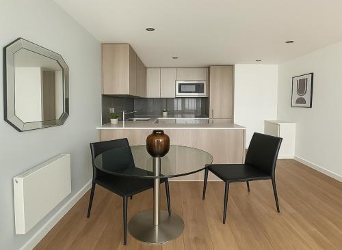a kitchen with a glass table and two chairs at 1 Bed Flat in Colindale in Colindale