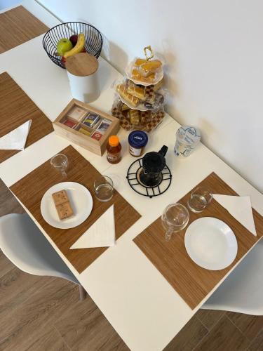 ein Tisch mit Tellern und Gläsern darauf in der Unterkunft Casetta Diana in Lido di Ostia