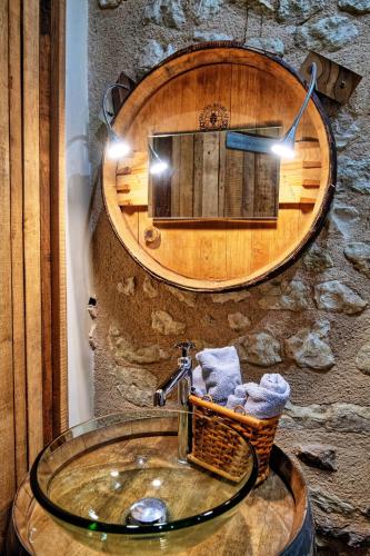 La salle de bains est pourvue d'un lavabo et d'un miroir circulaire. dans l'établissement Manoir au coeur des vignes, à Jaunay-Clan